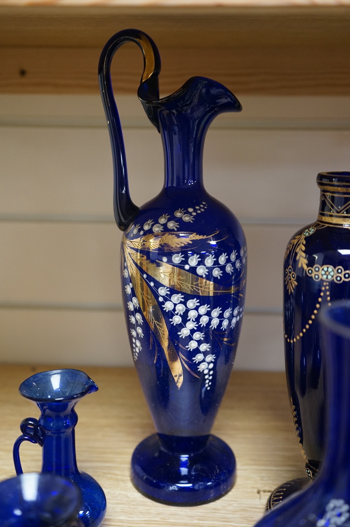A collection of Bristol blue glassware to include enamel and gilt decanters, together with other glassware, baskets etc, largest 33cm high